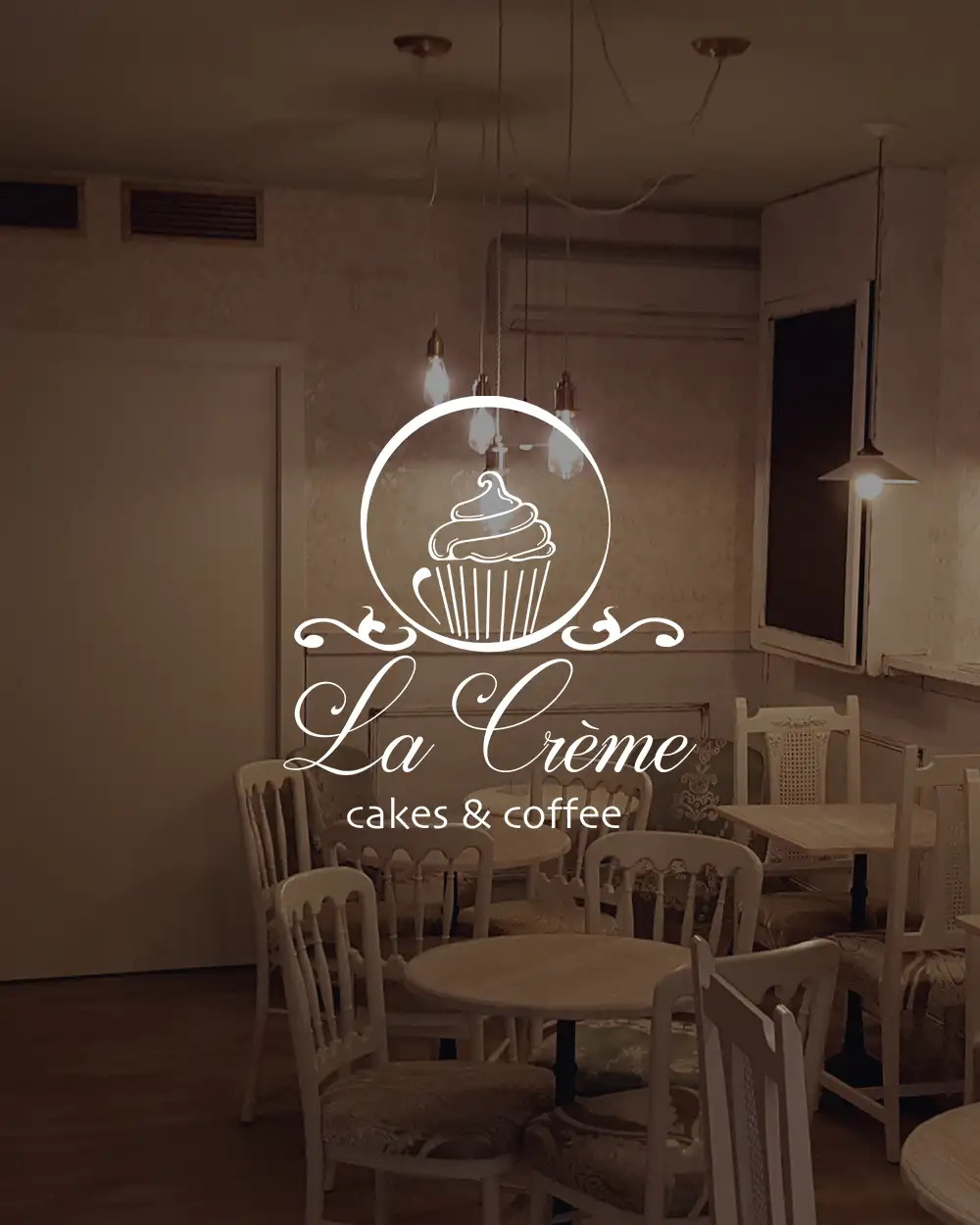 Logotipo de La Crème sobre el escaparate iluminado de la cafetería