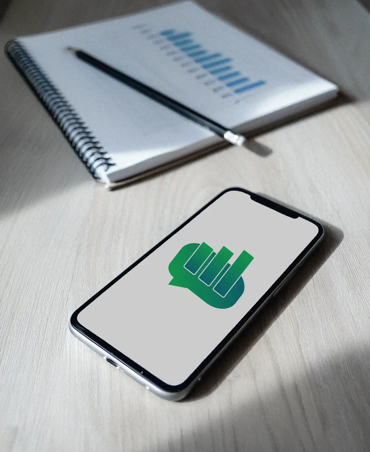 Móvil con una pantalla desenfocada junto a un cuaderno con una gráfica dibujada a mano