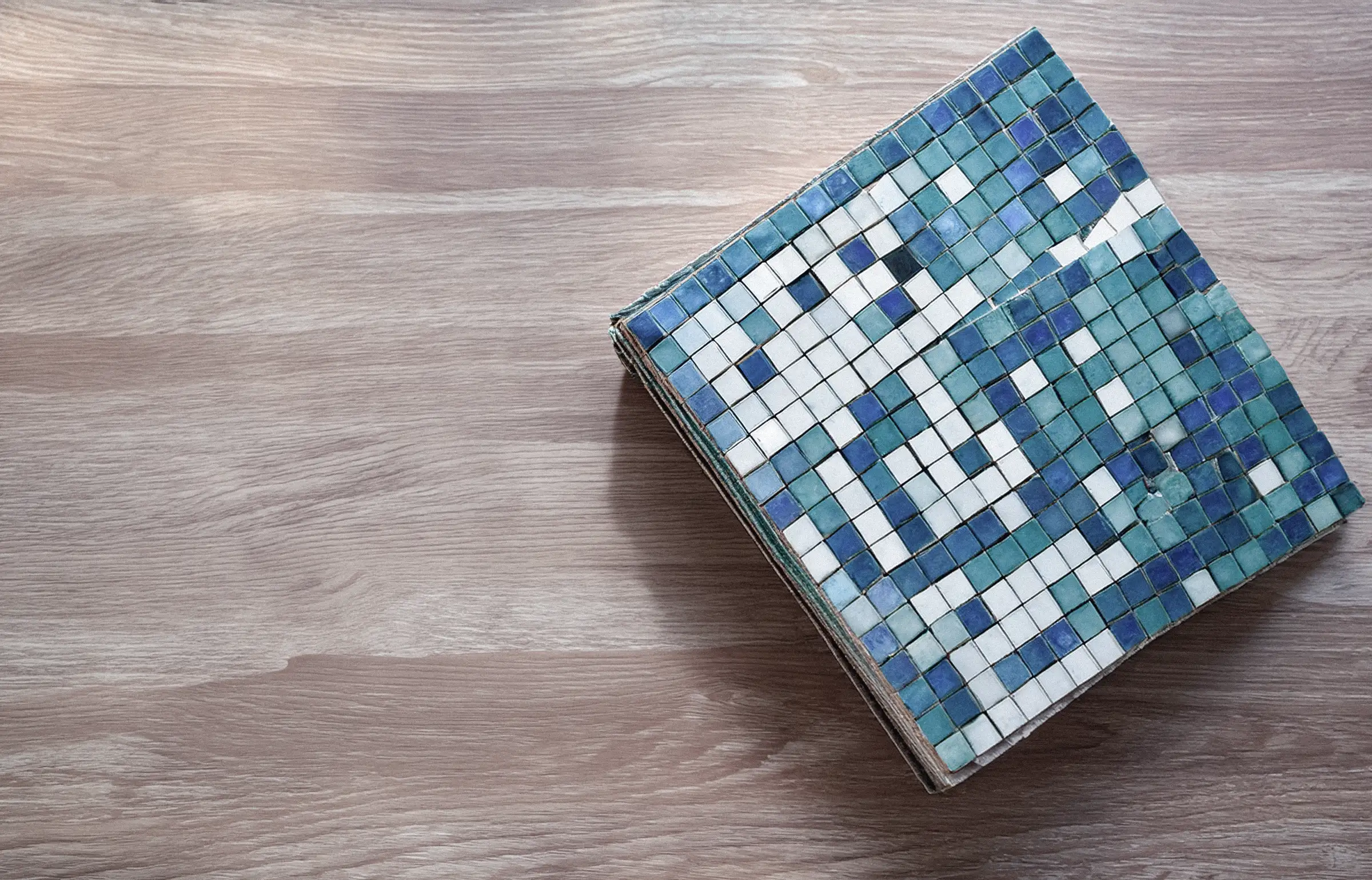 Web de Gaudí Crystal abierta en un portátil junto a azulejos decorativos apilados