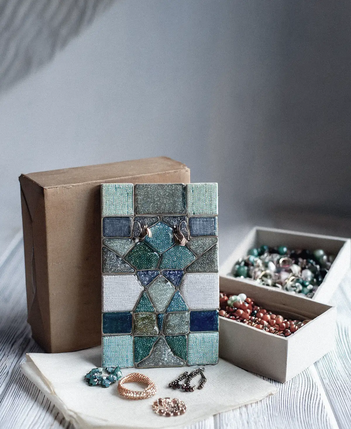 Azulejos decorativos con motivos de mosaico apilados sobre una mesa de madera